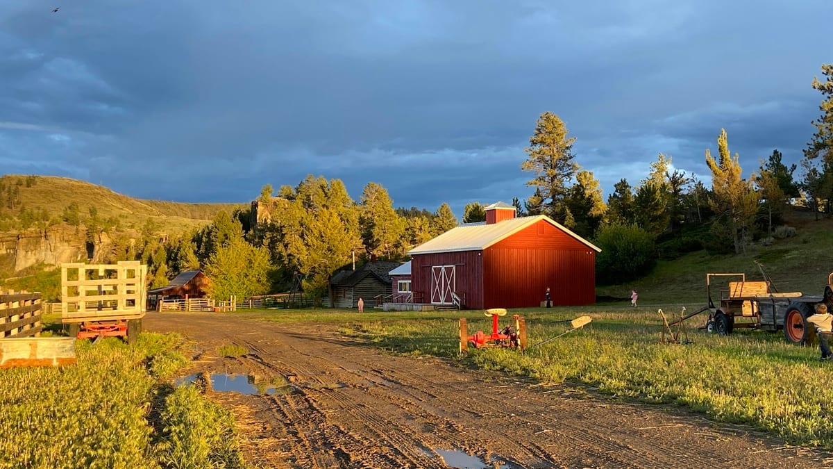 Family farm with a red barn at golden hour
