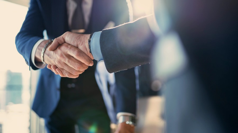Two business partners shaking hands after a financing agreement